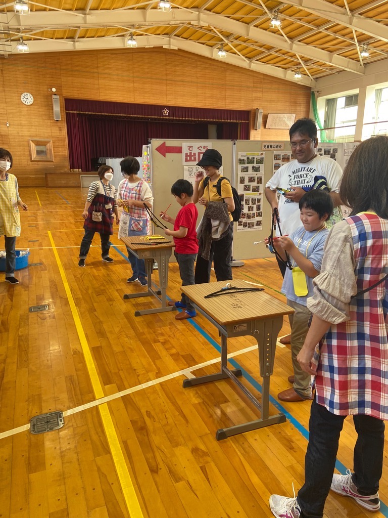 小学生がハンチェリーに挑戦しようとハンガーに弓を引っかけているところ