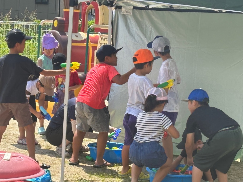 水遊びで水鉄砲の掛け合いを楽しんでいる子どもたち