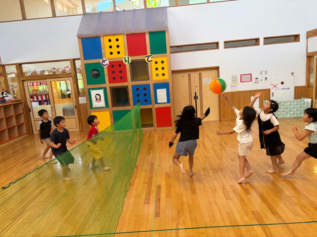 遊戯室でビーチボールを楽しむ子供たち