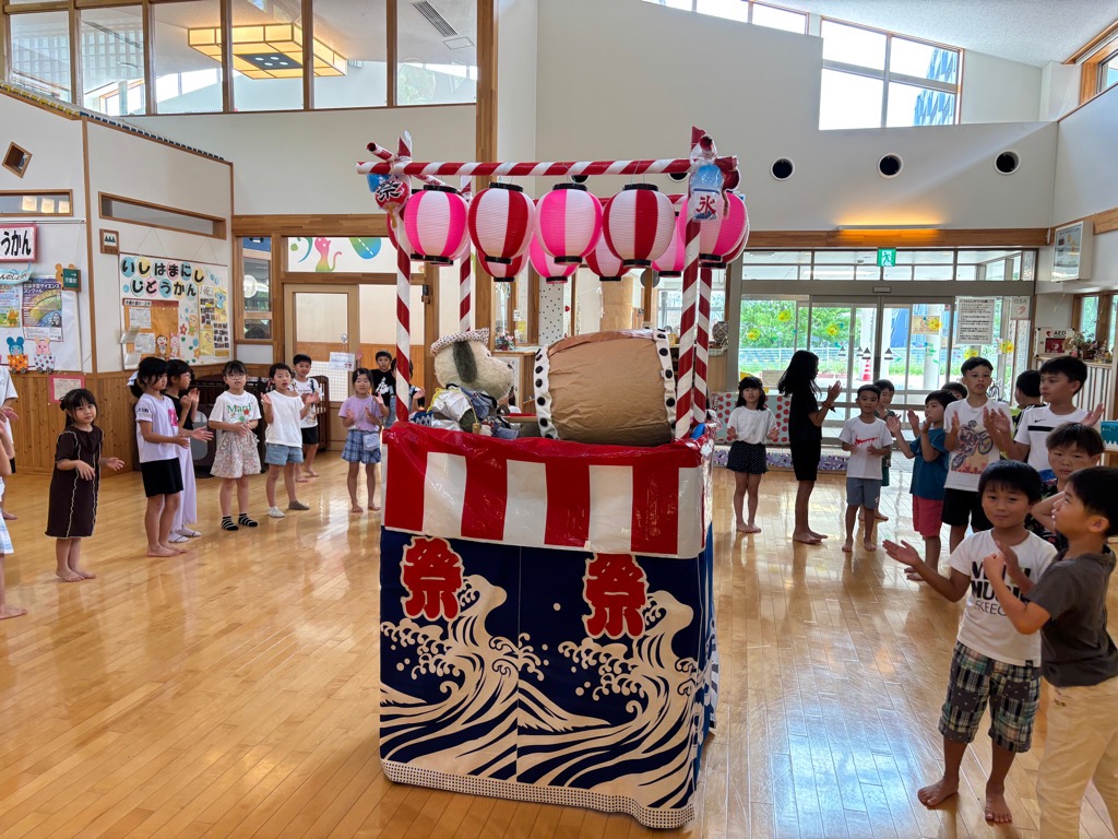 エントランスにある櫓を囲んで盆踊りをしている小学生たち