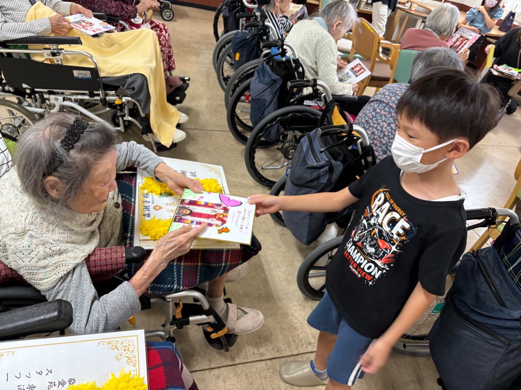 児童館の男の子がおばあちゃんにプレゼントを渡しているところ