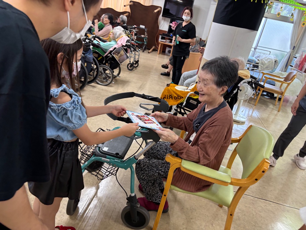 女の子がおばあちゃんにプレゼントを渡しているところ