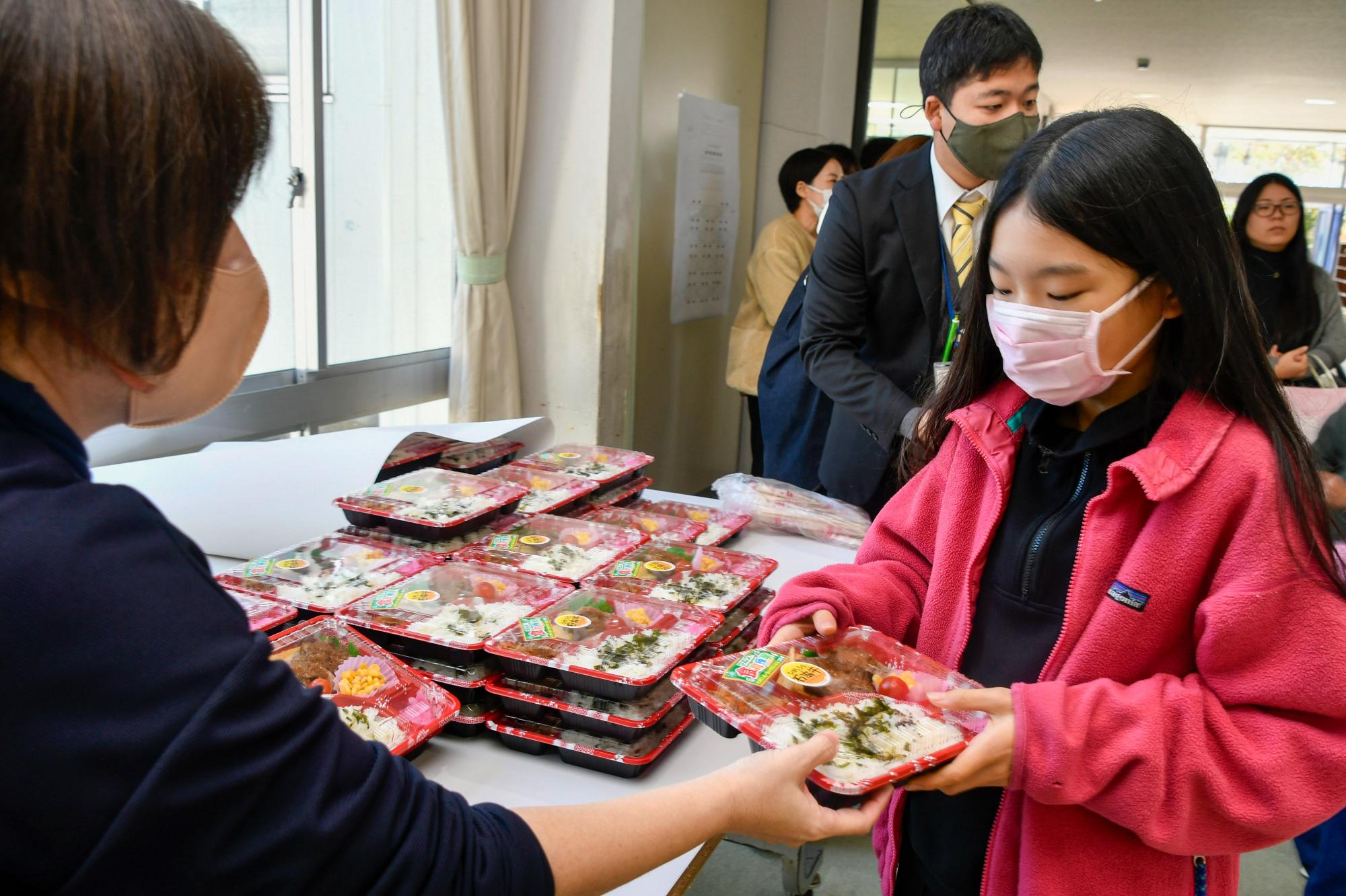 オリジナル弁当を手渡される児童