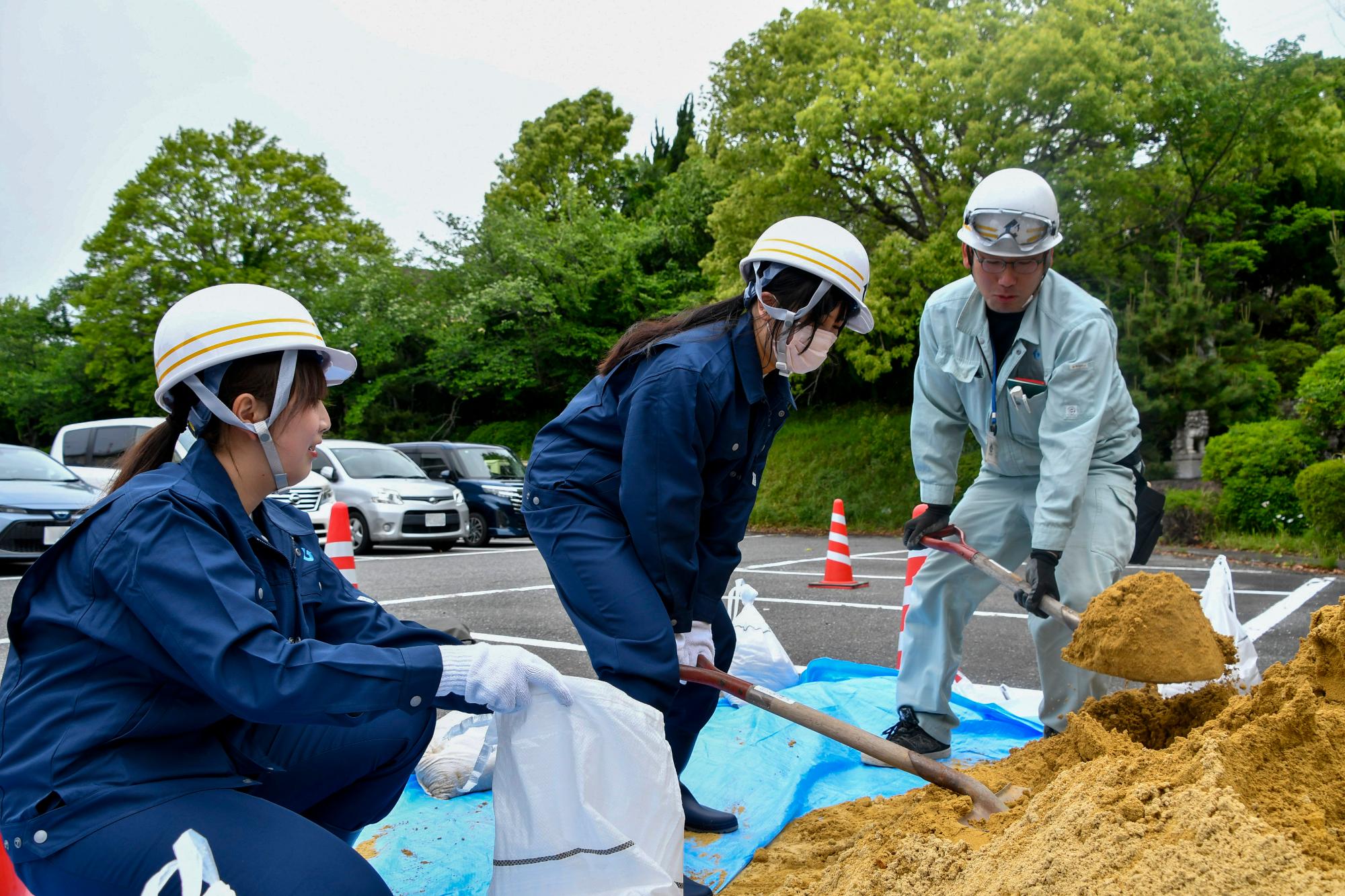 新規採用職員が土のう作りを学ぶ様子
