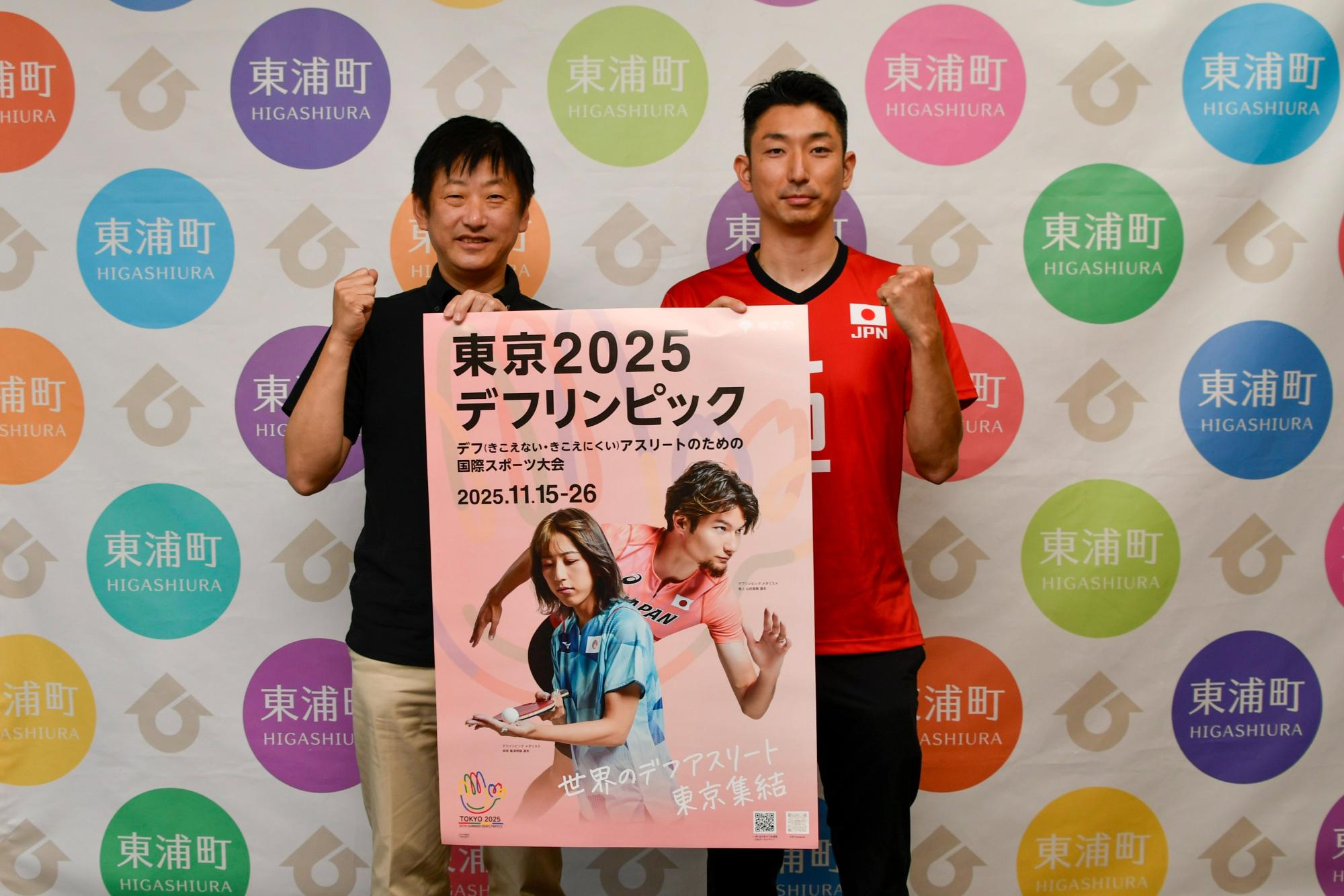 デフリンピックのポスターを手にする町長と高橋選手