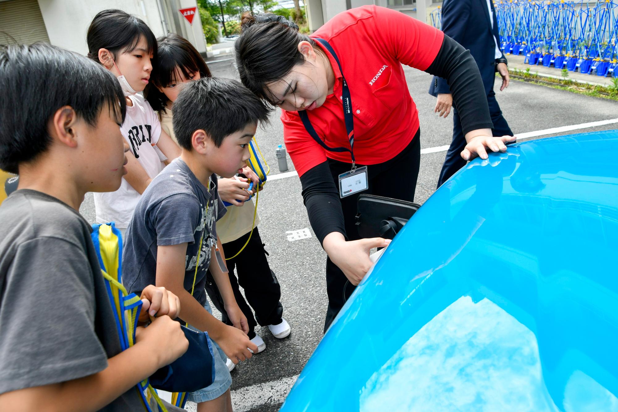 電気自動車の使い方を教わる児童の様子