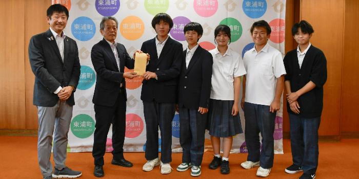 町福祉協議会の方へ収益金を寄付する生徒たち