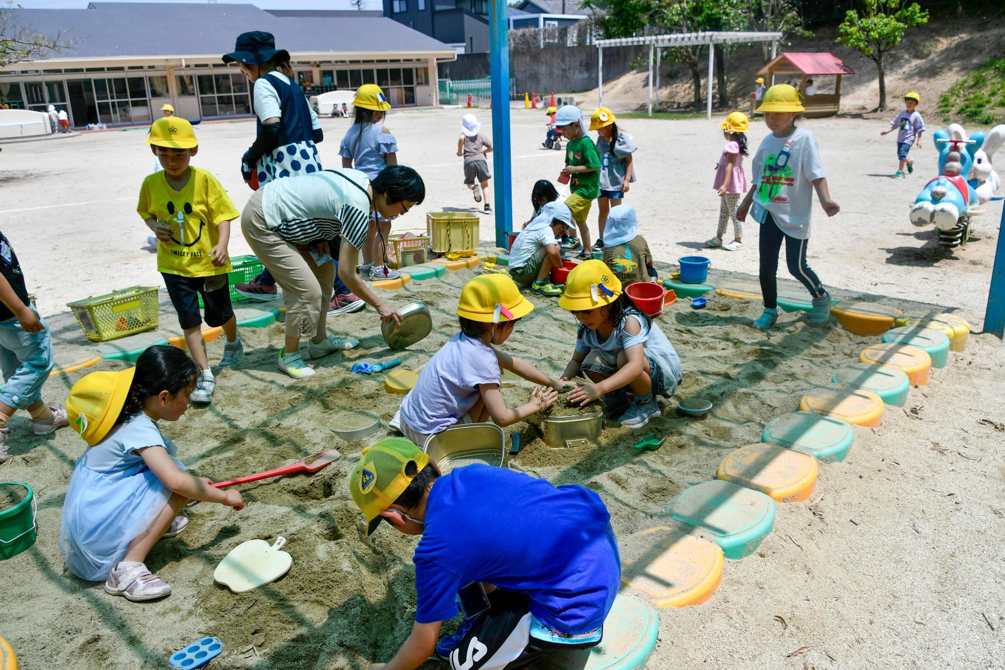 緒川新田保育園の園庭で一緒に遊ぶ園児と児童