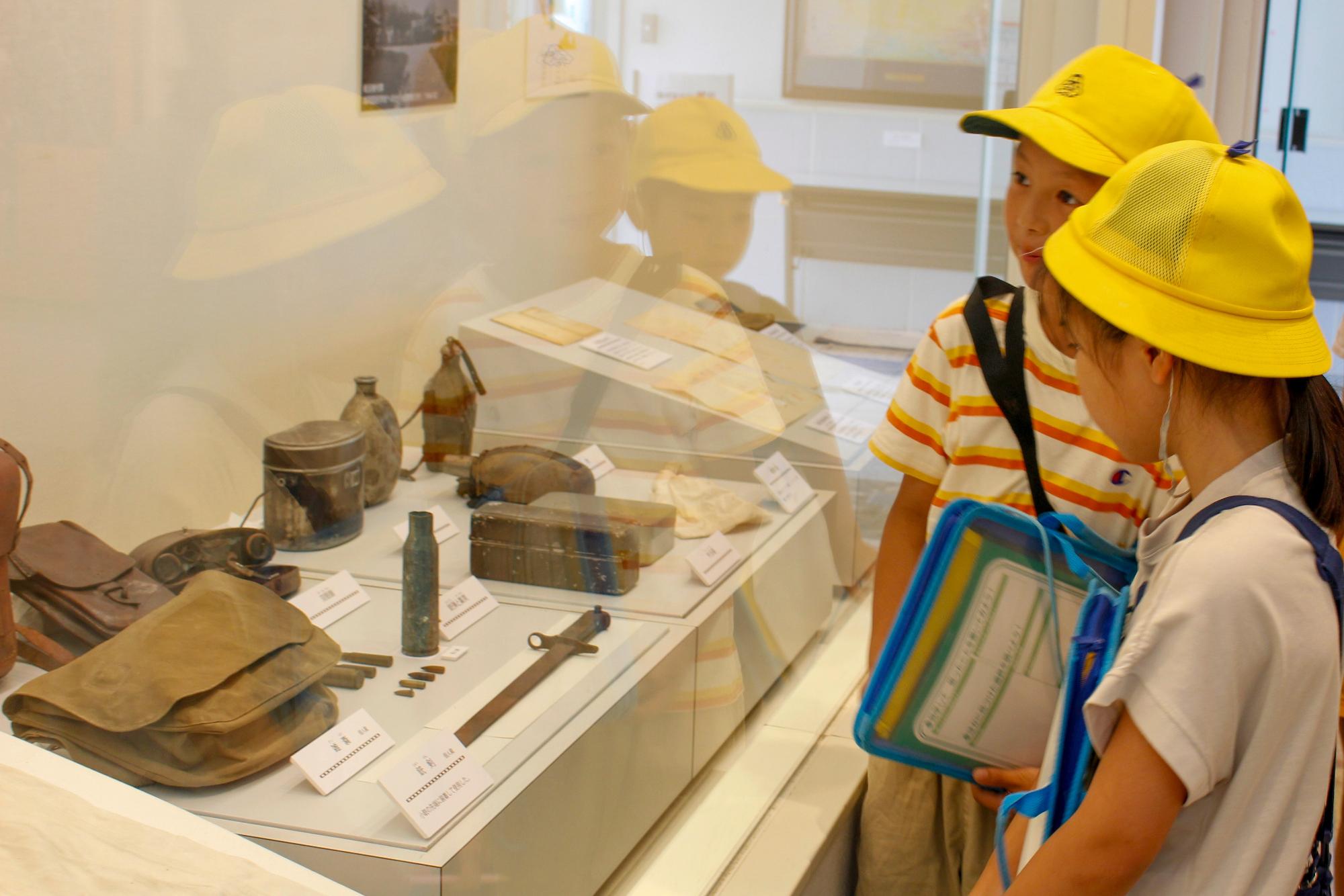 「戦争と平和」の展示物を見る児童