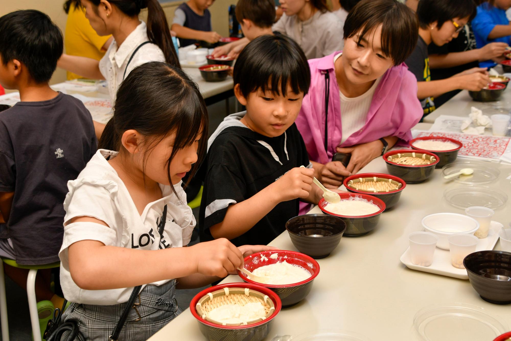 ざるに豆腐をあげて水切りをする