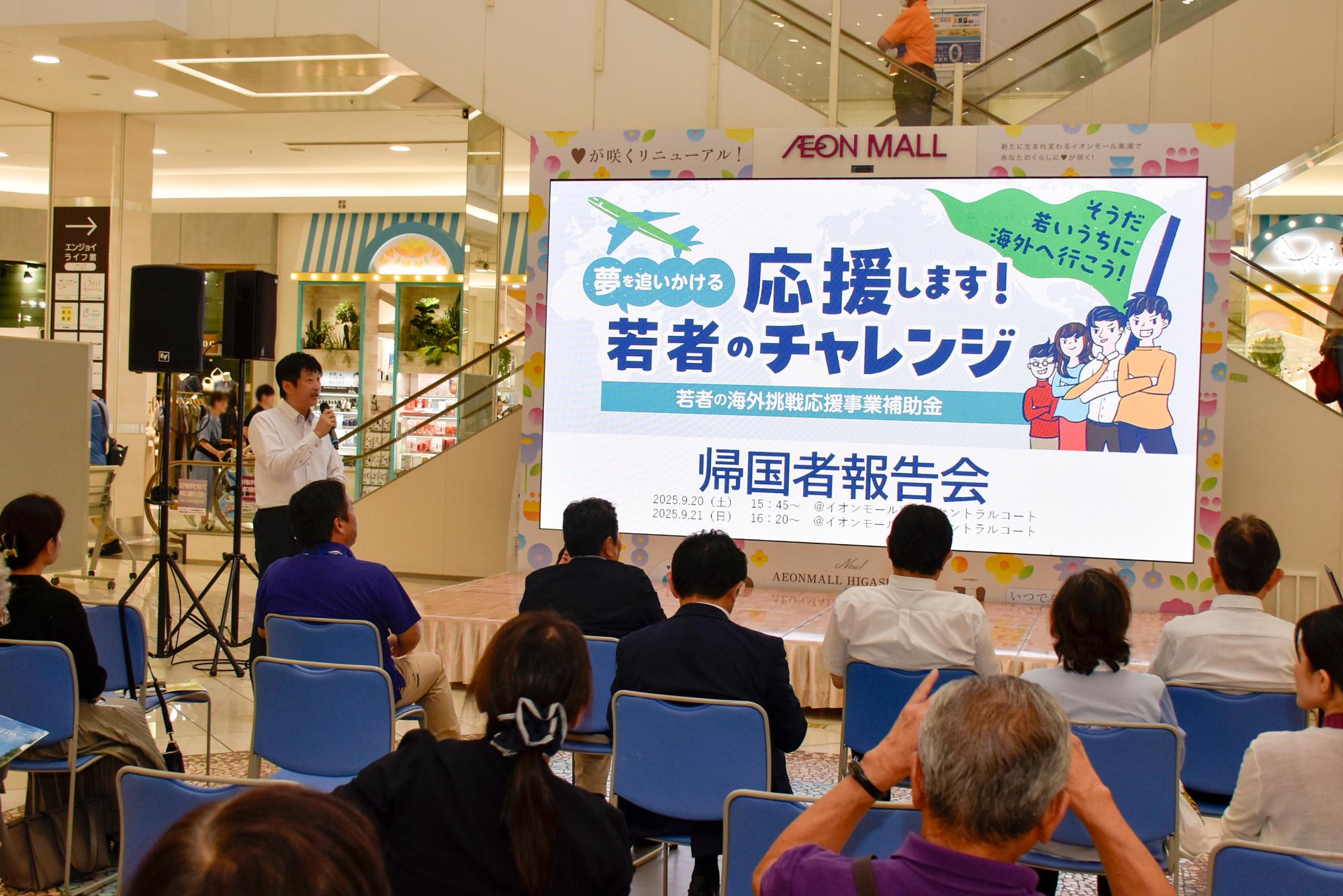 報告会で挨拶をする町長