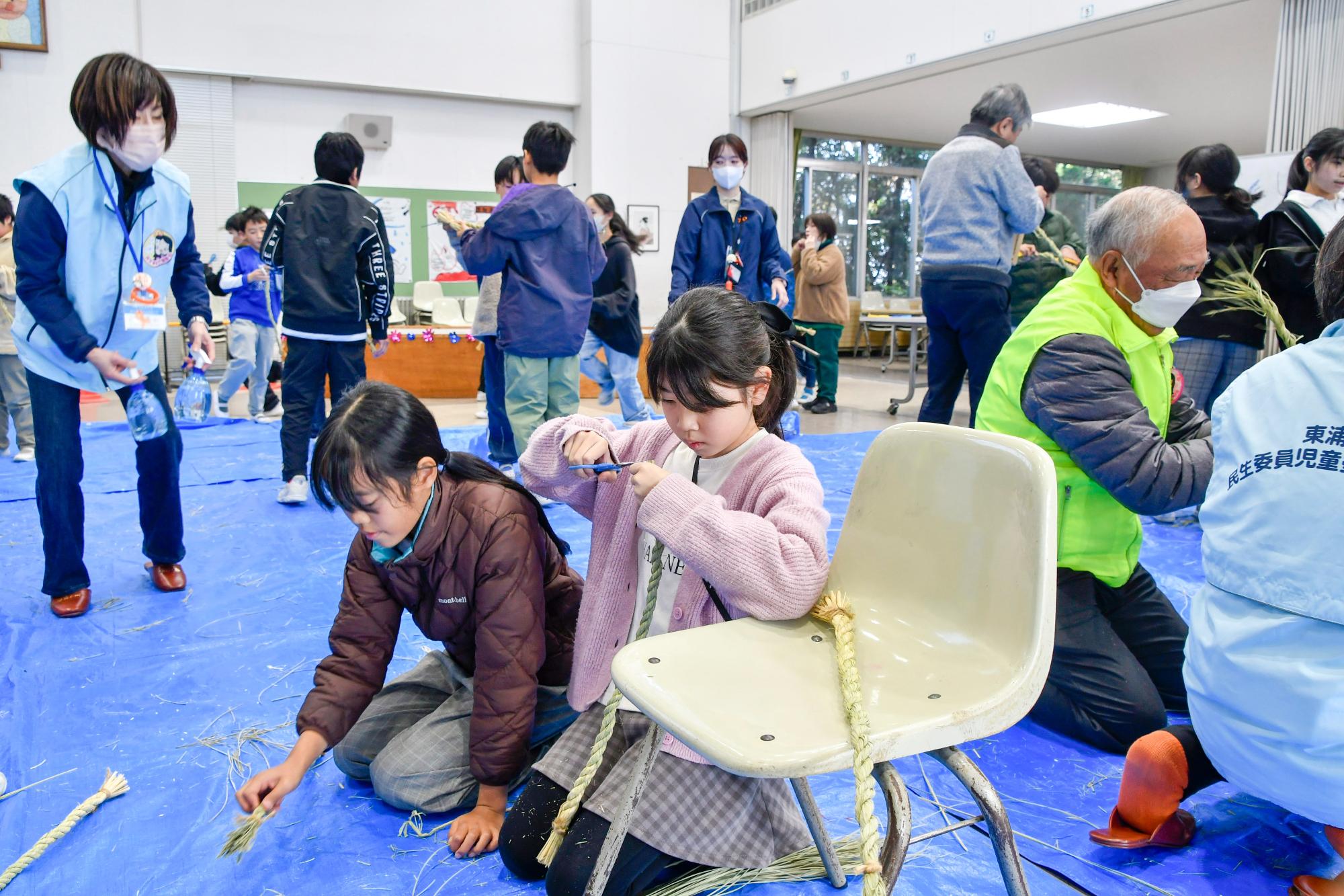 しめ縄の端を切りそろえる児童