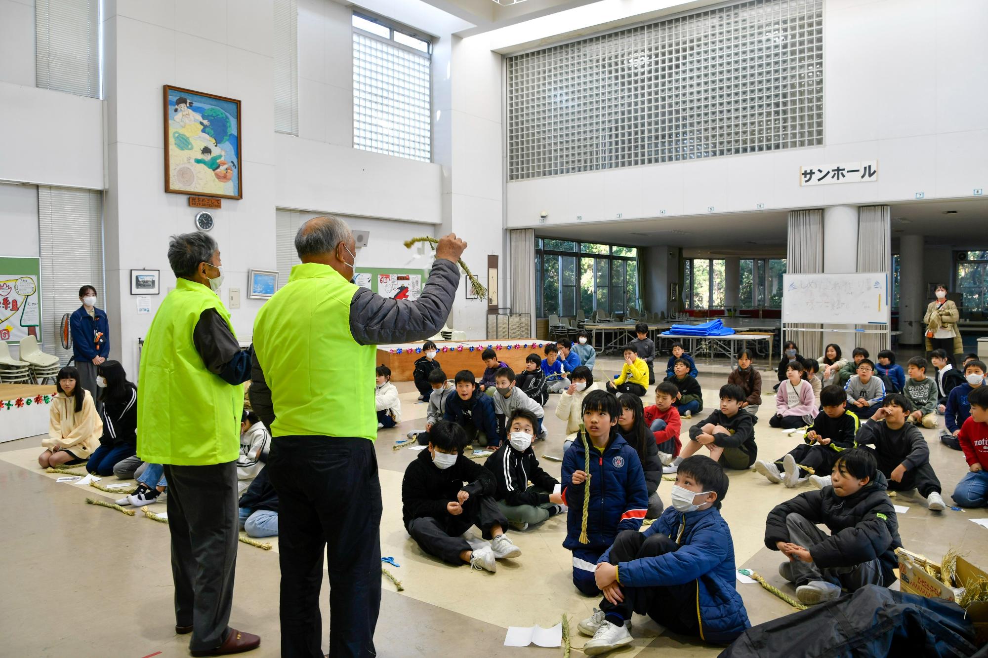 しめ縄づくりの説明を聞く児童たち