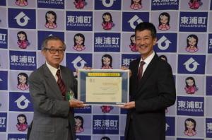 藤江小学校ユネスコスクール加盟承認証を持つ教育長と校長の写真