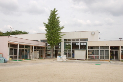 緒川保育園の外観を写した写真。手前に運動場があり奥に建物が建っている。