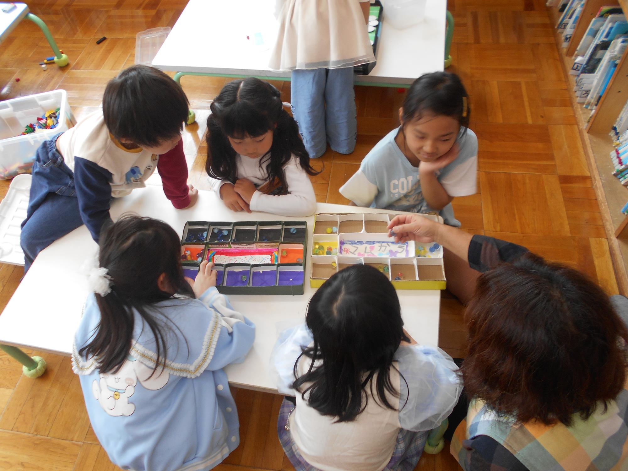 異年齢でマンカラを楽しんでいる。