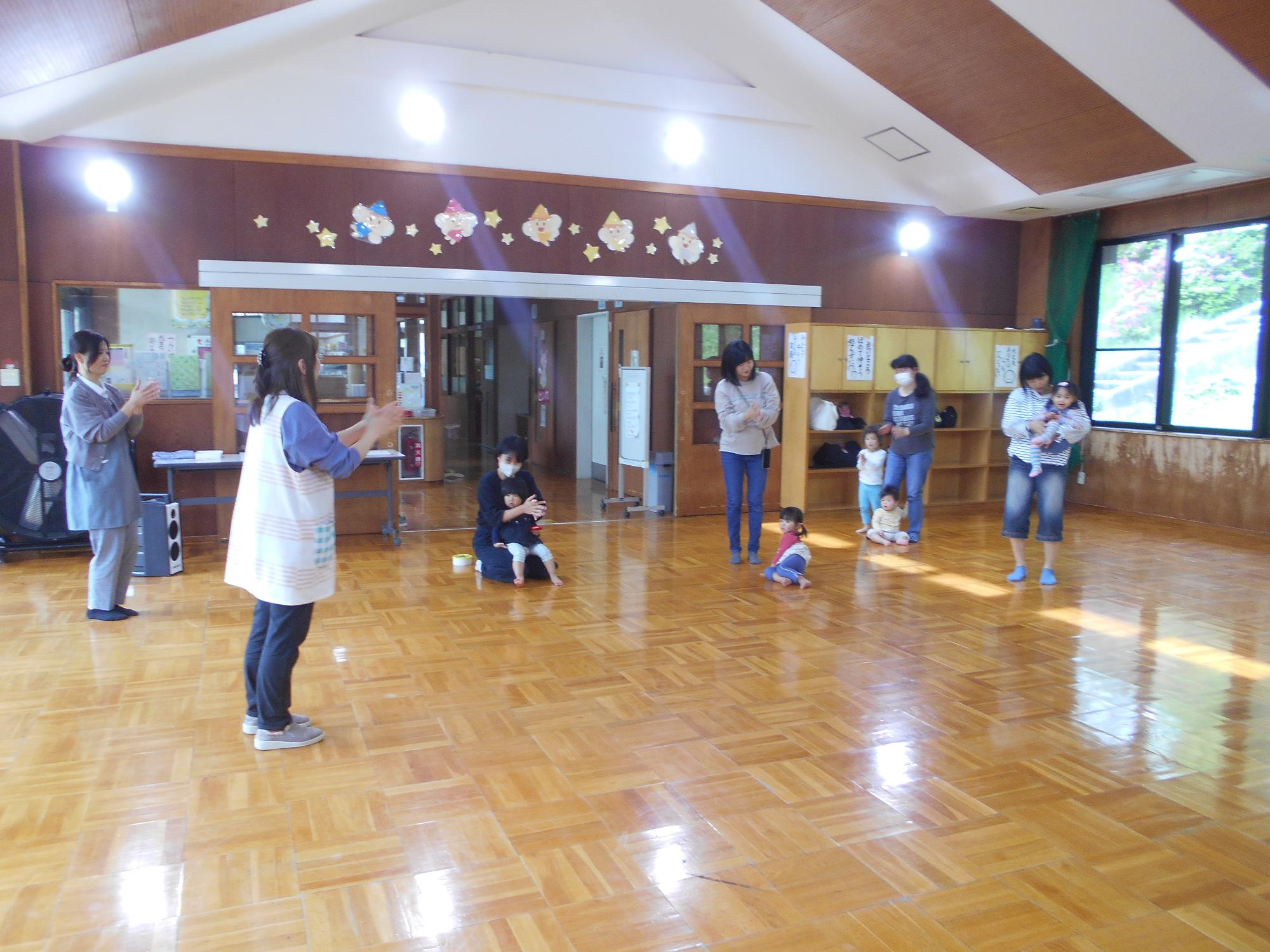 職員が見本で親子でふれあい遊びを楽しんでいる。