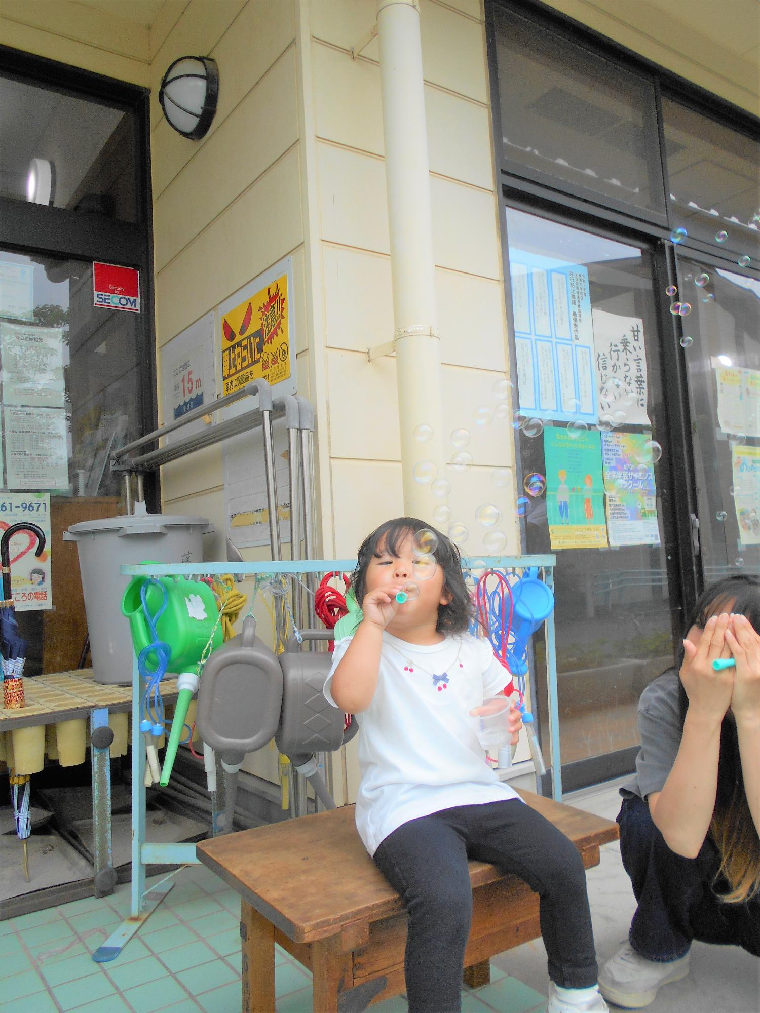 女の子こがしゃぼんだまを吹いているところ