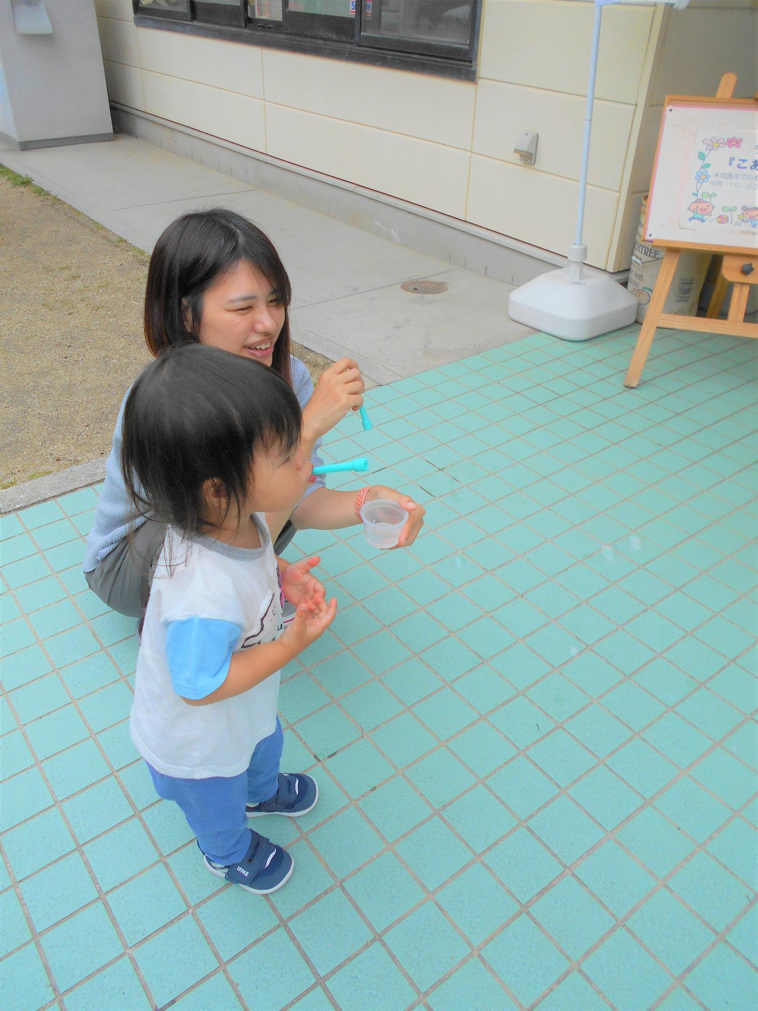 女の子がしゃぼんだまを吹いているところ