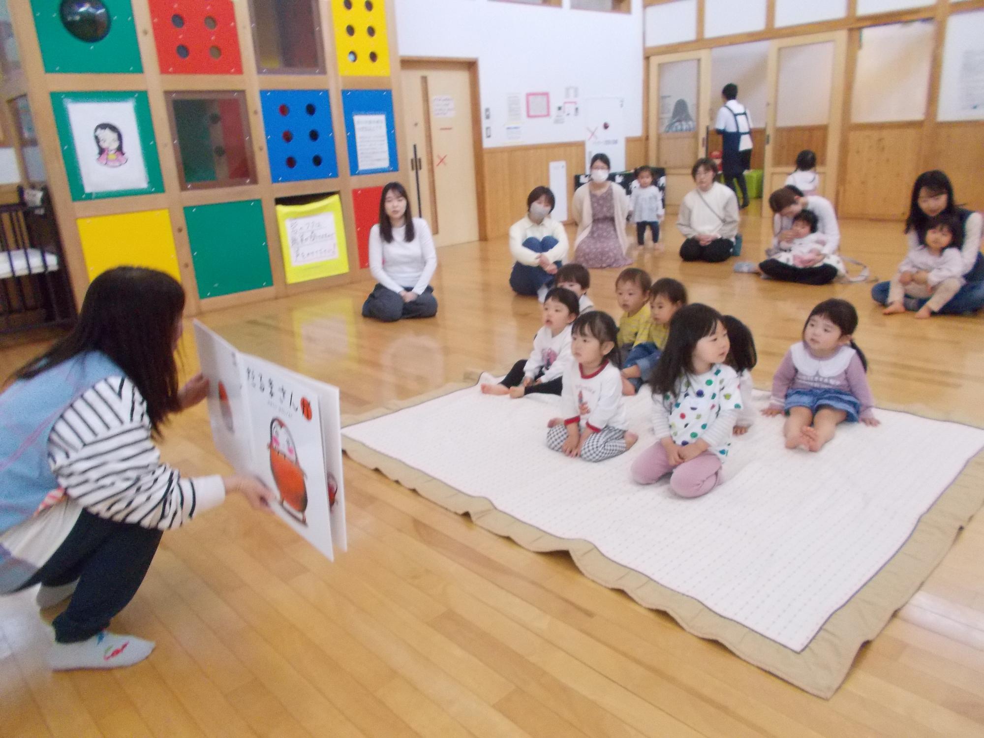 子どもたちに大型絵本の読み聞かせをしているところ