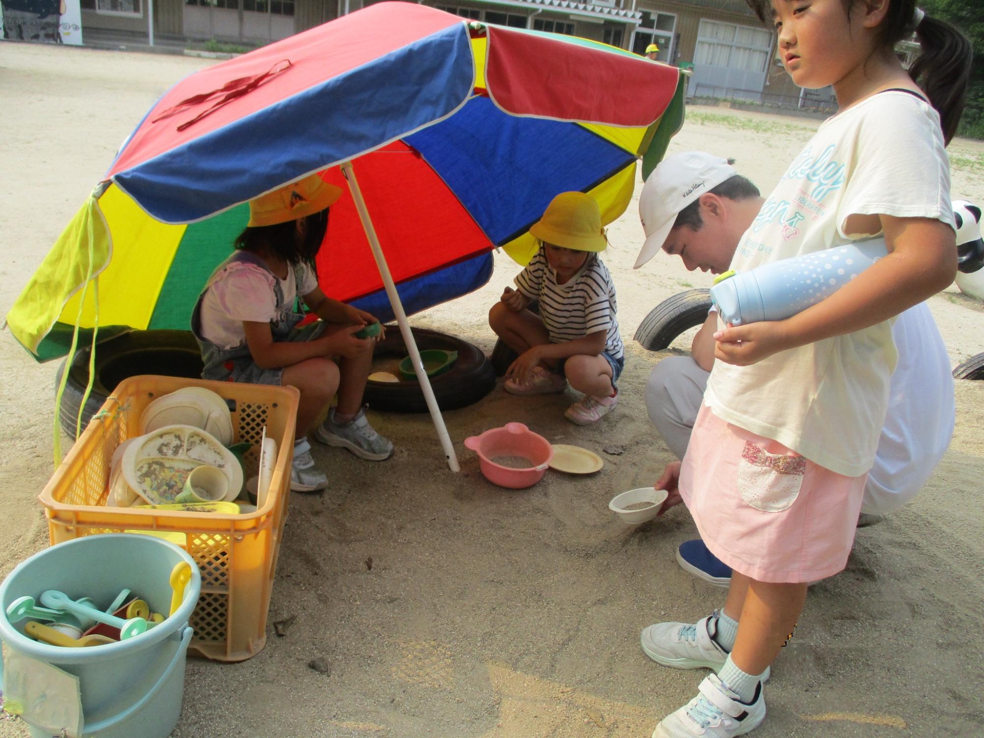 パラソルの陰であそぶ子どもたち