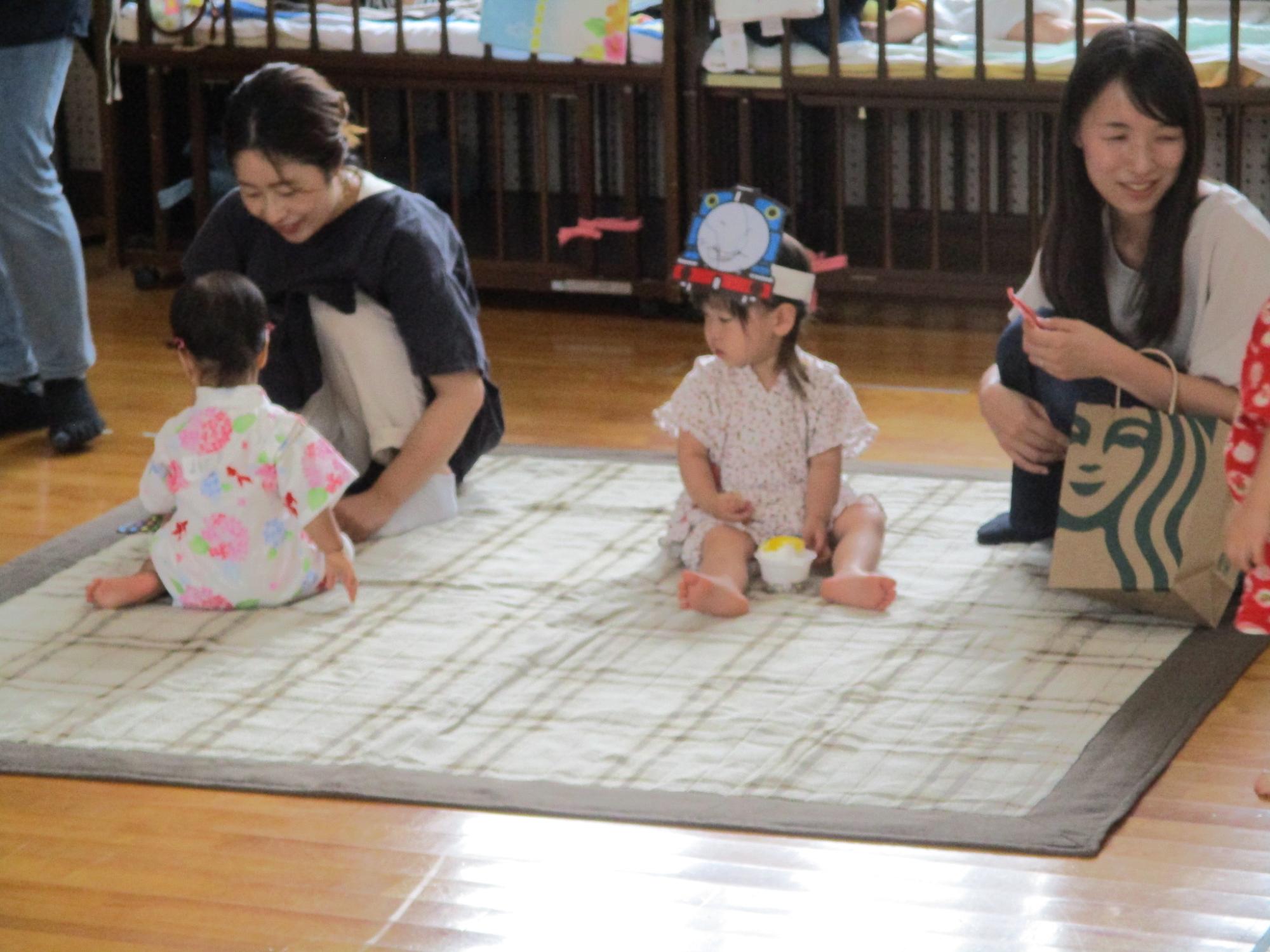 縁日ごっこで作ったものを食べるまねっこを楽しむ親子