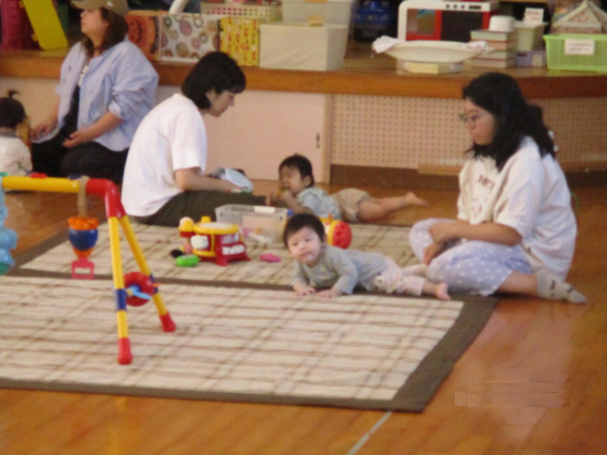 赤ちゃんを見守りながらお話しする保護者達