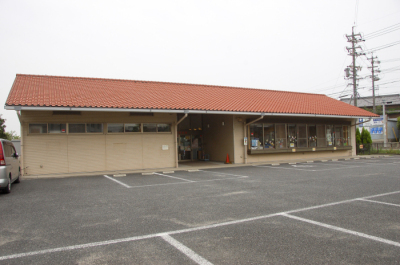 生路児童館の外観を写した写真。中央に建物が写っており、手前には駐車場がある。