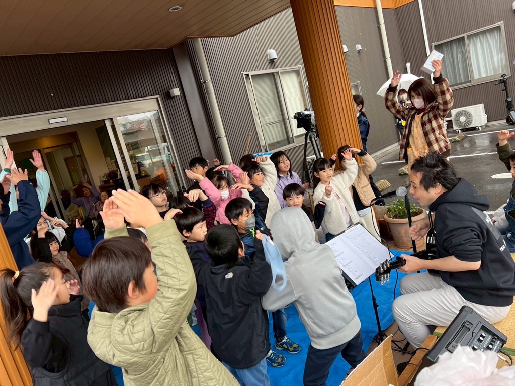 敬愛苑職員さんがギターで子どもたちが歌をうたっているところ