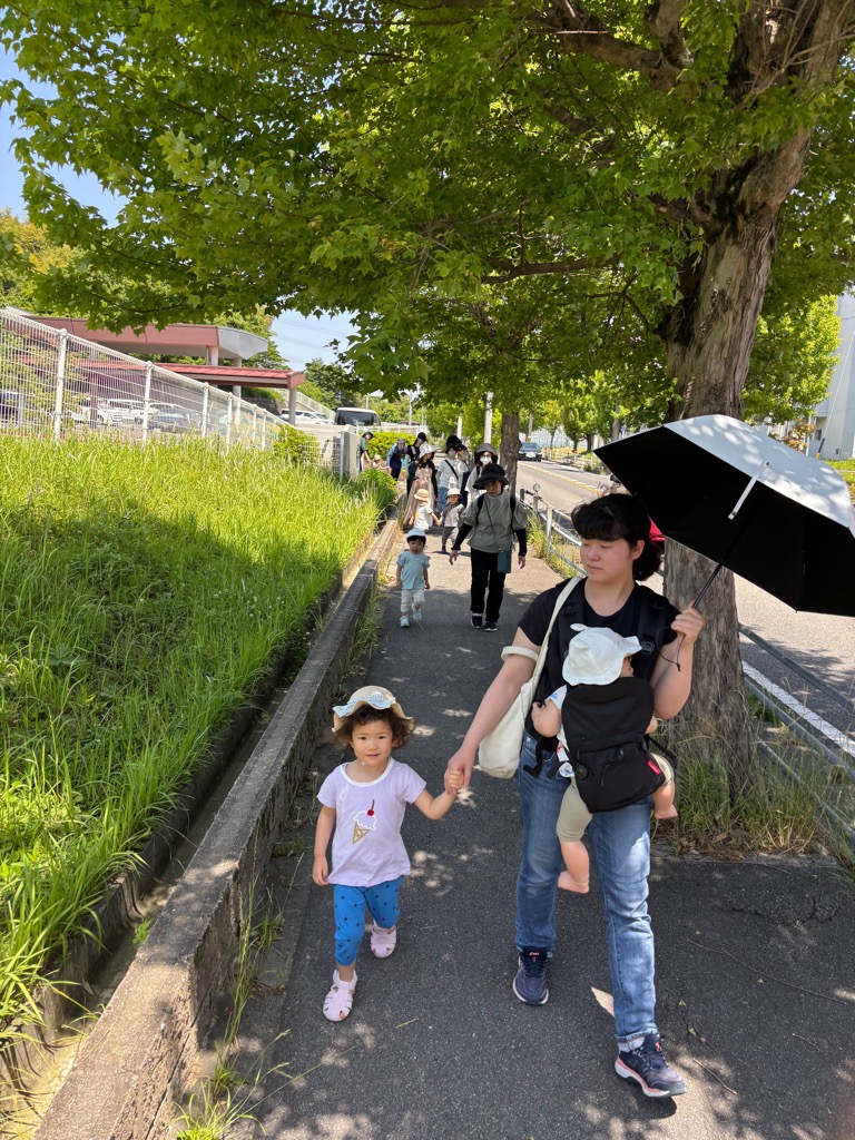 親子で手をつないで公園まで歩いているところ