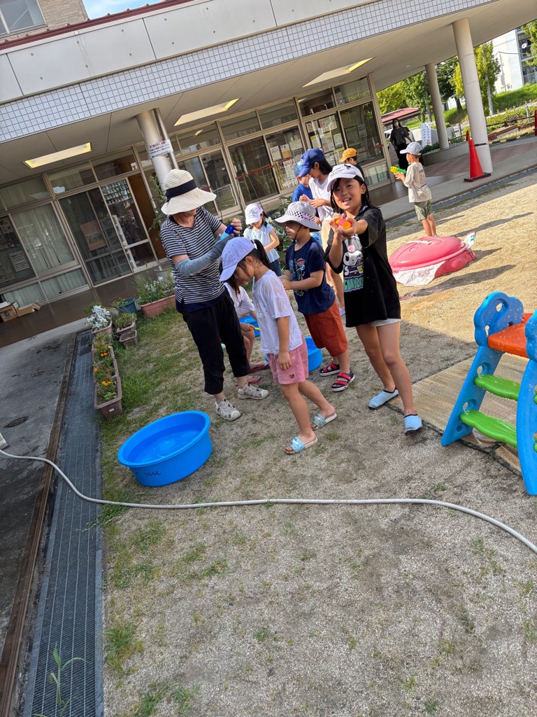 女児が水鉄砲をこちらに向けて水をかけようとしているところ