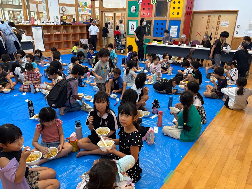 こどもたちと老人ホーム敬愛苑の入居者さんが一緒にカレーを食べているところ