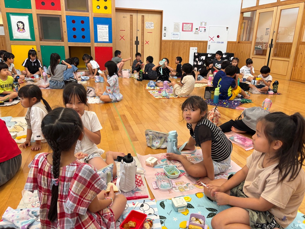 遊戯室で友達と一緒におしゃべりしながら昼食を楽しそうに食べているところ
