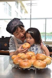 できたてのパンを食べる女の子とお母さん