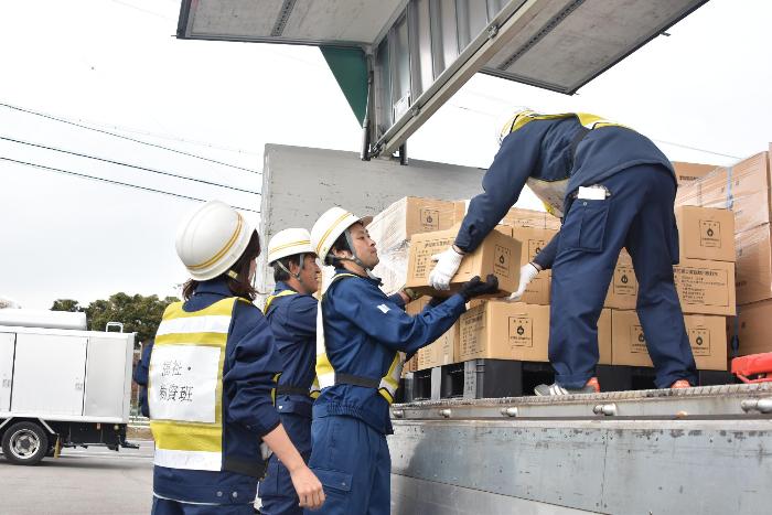 トラックから手で積み荷を降ろす様子