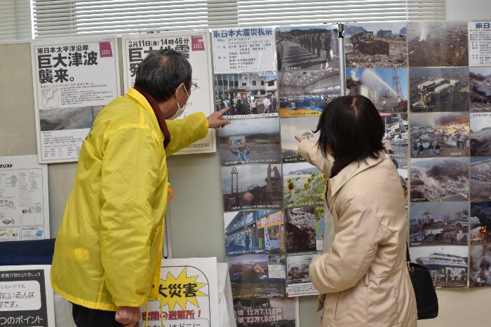 東日本大震災の視察で撮影した被災地の写真を見る様子