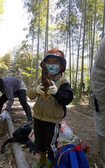 掘った竹の子をもって嬉しそうにする子ども