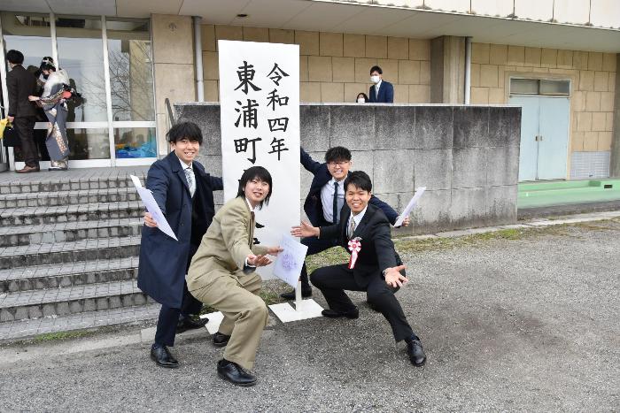 成人式の看板の前でポーズをとる様子