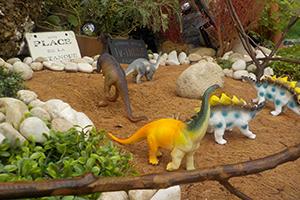 箱庭に置かれた恐竜の人形の写真
