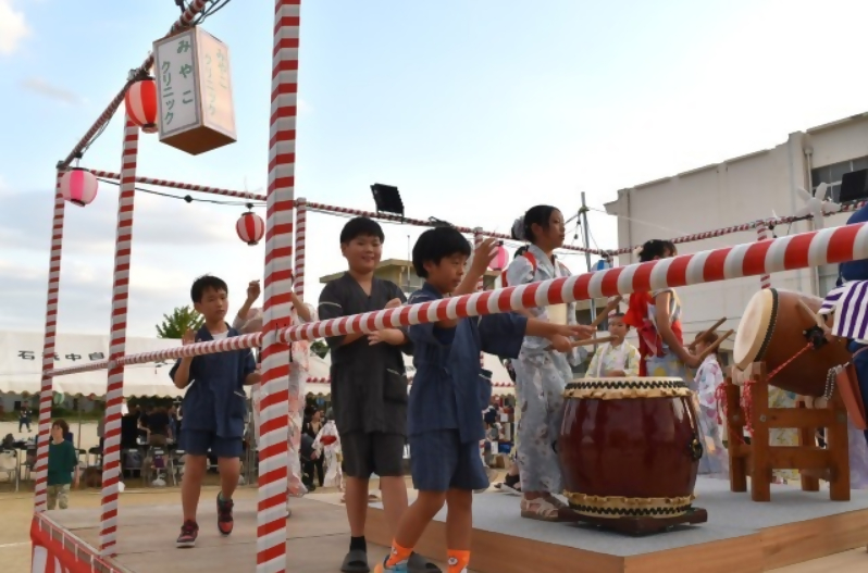 片葩小学校の子どもたちが地域の盆踊りで太鼓をたたいたり踊ったりしてがんばっています。