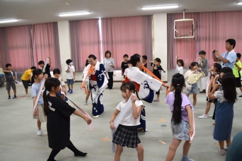 喜生会さんから東浦小唄を教えていただき、まめしぼりを持って楽しく踊る3年生の子どもたち
