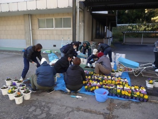 卒業式・入学式に向けた花の定植作業をする東中サポーターの皆さん