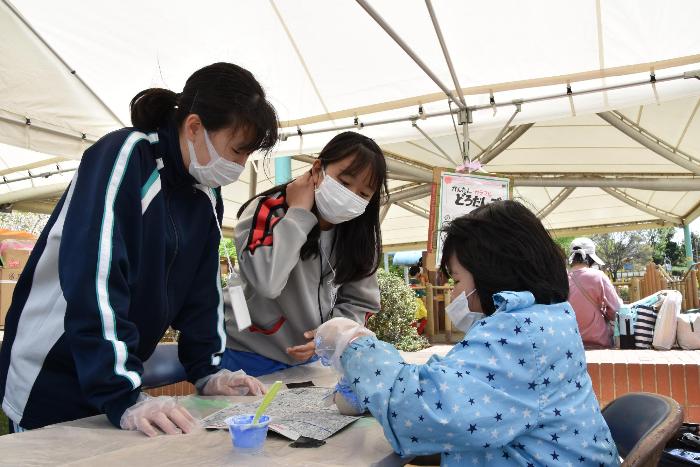 於大まつりで泥団子づくりを教える中学生