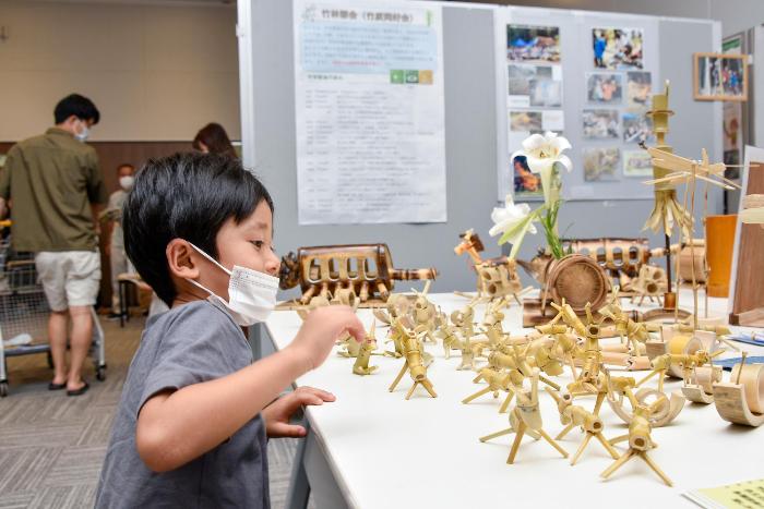 竹で作成された動物たちに見入る子ども