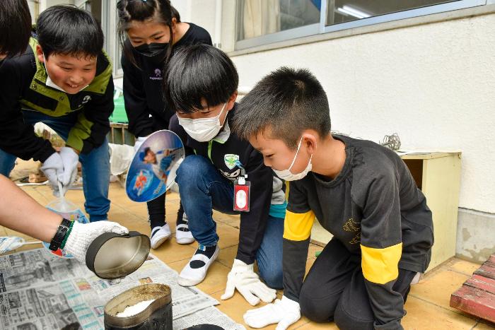 炊けた飯ごうの様子をのぞき込む児童