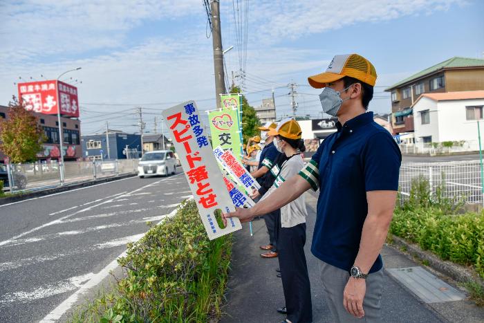 運転者にプラカードで交通安全啓発を行う職員