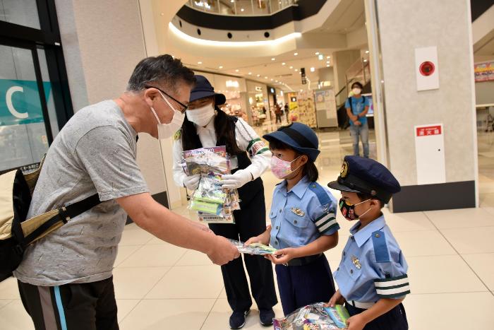 啓発品を渡すちびっこ警官