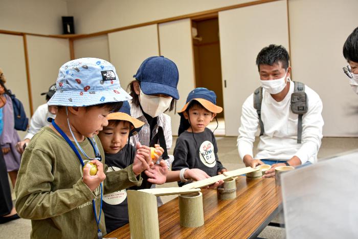 竹で作成した道筋にボールを流そうとする参加者