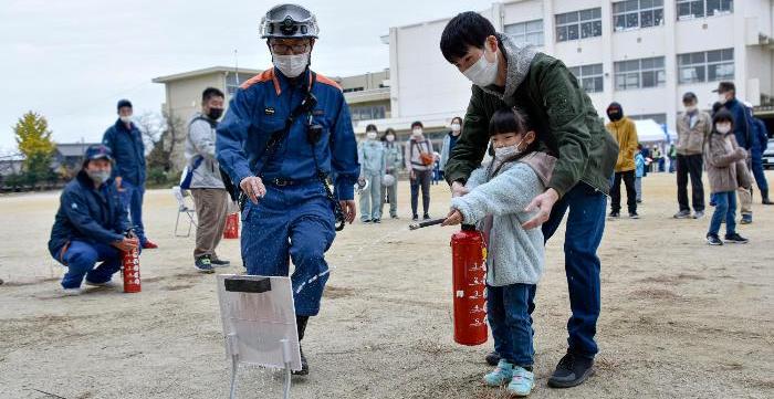 消火器の使用の仕方を学ぶ住民