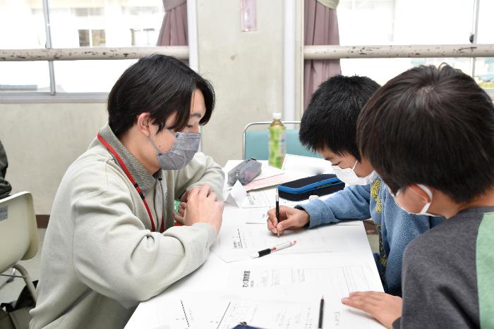 小学生が問題を解く様子をみるスクールガード